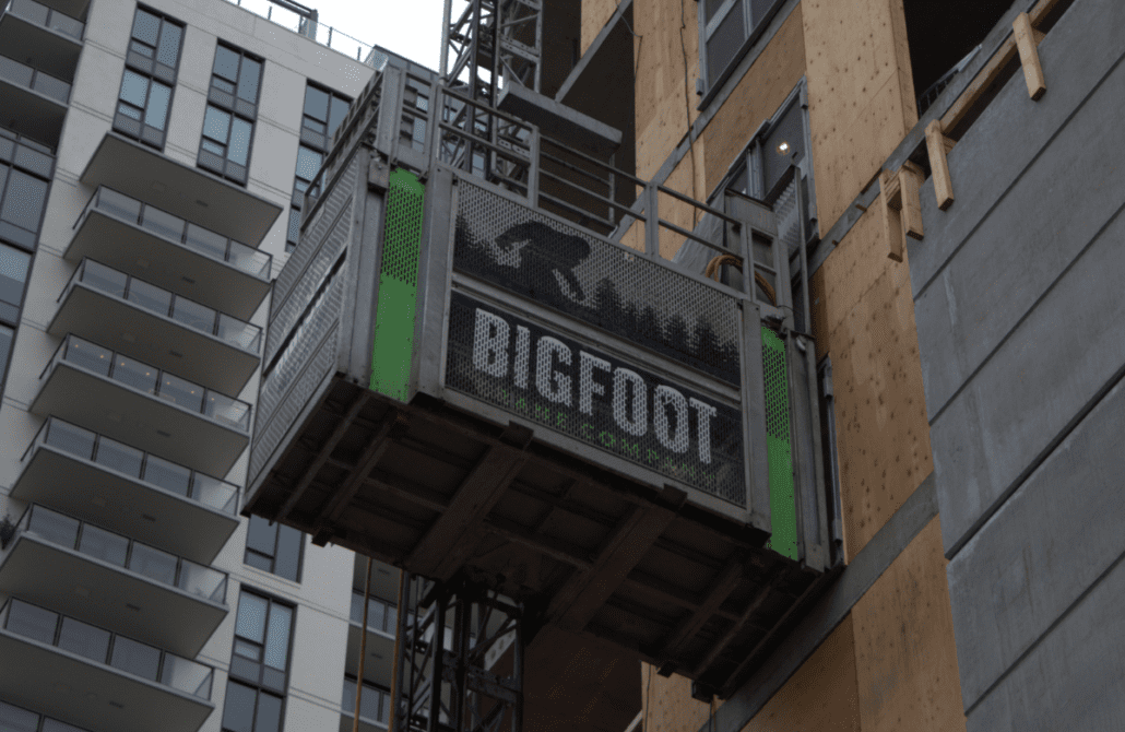 A Bigfoot Academy instructor providing hands-on hoist operator training inside a personnel lift car. 