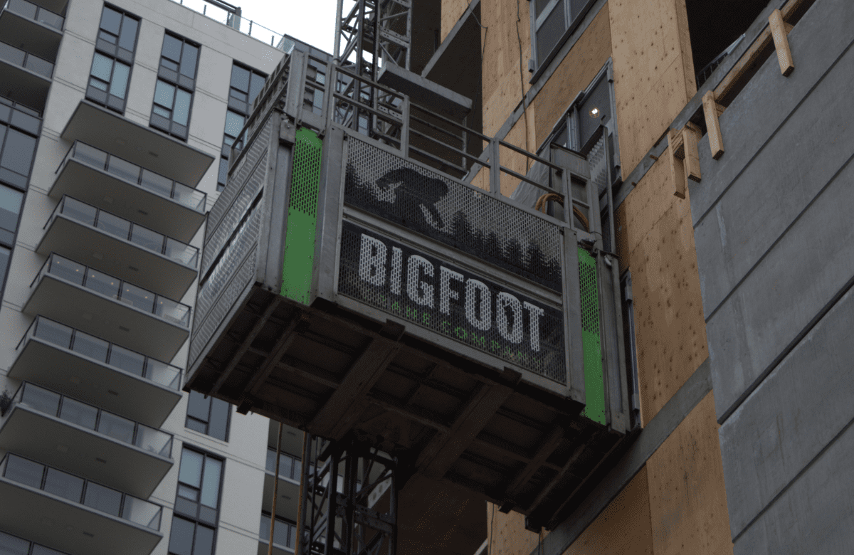 A Bigfoot Academy instructor providing hands-on hoist operator training inside a personnel lift car.