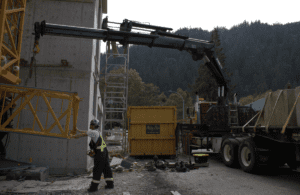 A certified operator skillfully maneuvering a red folding boom (knuckle boom) crane during a training exercise at Bigfoot Academy. 