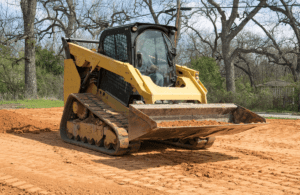 Bigfoot Academy instructor teaching a worker how to operate a skid steer loader safely on-site. 