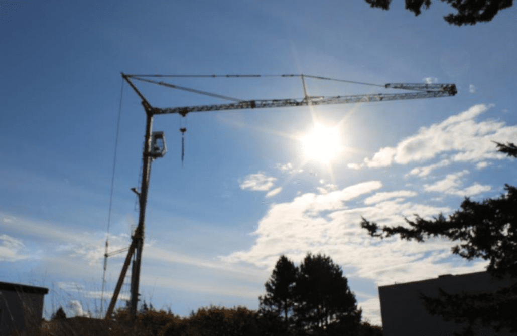 A well-maintained 1999 Potain HD40 A self-erecting tower crane on a construction site, for sale by Bigfoot Crane. 