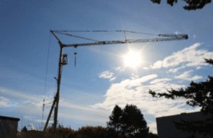 A well-maintained 1999 Potain HD40 A self-erecting tower crane on a construction site, for sale by Bigfoot Crane. 