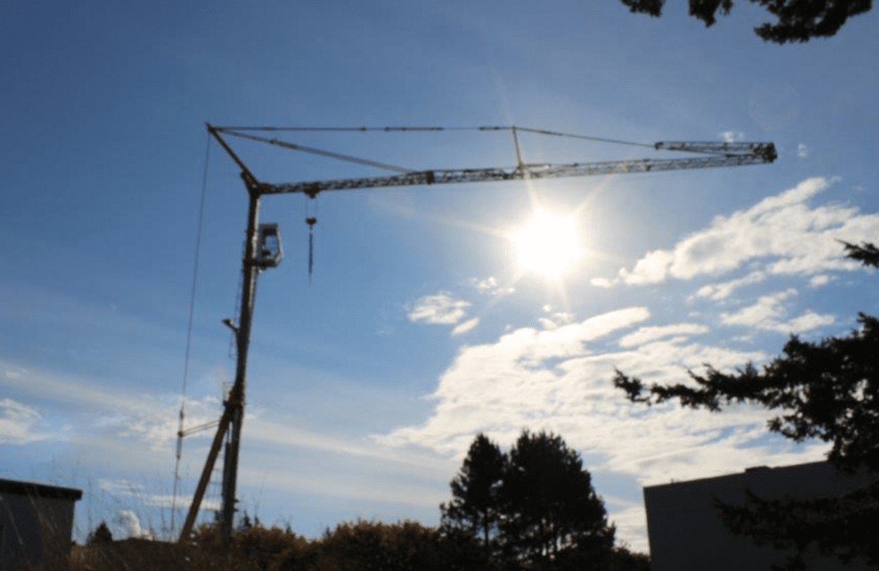 A well-maintained 1999 Potain HD40 A self-erecting tower crane on a construction site, for sale by Bigfoot Crane. 