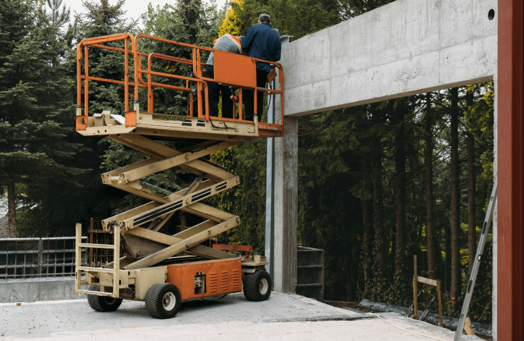 Workers in a scissor lift receiving on-site safety training from a Bigfoot Academy instructor. 