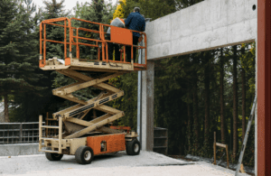 Workers in a scissor lift receiving on-site safety training from a Bigfoot Academy instructor. 
